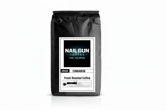 Nail Gun Coffee in a black bag on white background with Cinnabun flavored coffee beans 