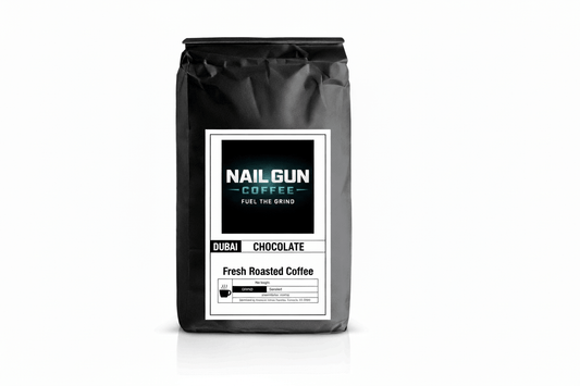 Nail Gun Coffee in a black bag on white background with Dubai Chocolate flavored coffee beans